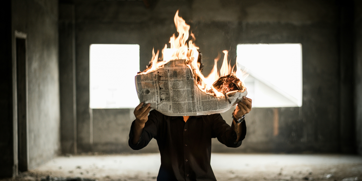 man burning a newspaper